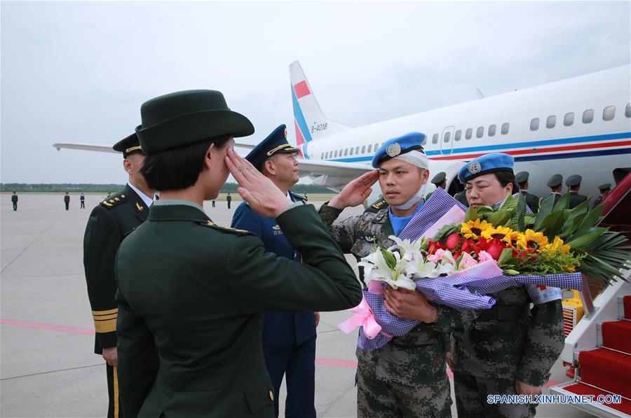 El soldado chino de las fuerzas de paz de la Organización de las Naciones Unidas (ONU), Yang Zhancheng (2-d), quien resultó herido en un atentado terrorista en Mali, recibe flores en el Aeropuerto Longjia en Changchun, capital de la provincia de Jilin, en el noreste de China, el 9 de junio de 2016. El cuerpo del soldado chino de las fuerzas de paz de la Organización de las Naciones Unidas (ONU) Shen Liangliang, quien murió en un ataque terrorista en Mali el mes pasado, arribó la tarde del jueves a la ciudad de Changchun, en el noreste de China. (Xinhua/Yin Gang)