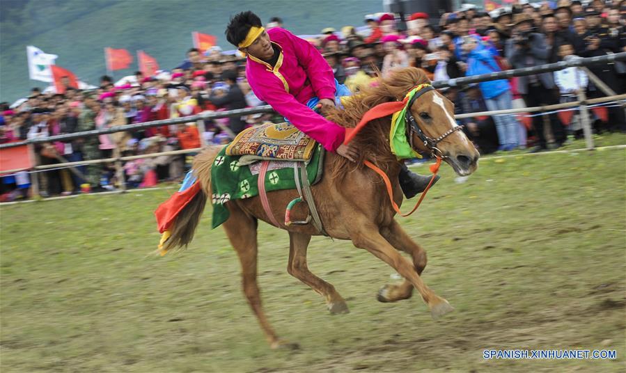 Un jinete realiza una presentación durante un festival de carreras de caballos en Shangri-la, Prefectura Autónoma Tibetana de Diqing, en la provincia de Yunnan, en el suroeste de China, el 9 de junio de 2016. Un total de 194 caballos participarán en el festival étnico tradicional de tres días de duración, que dio inicio el jueves. (Xinhua/Zhou Lei)