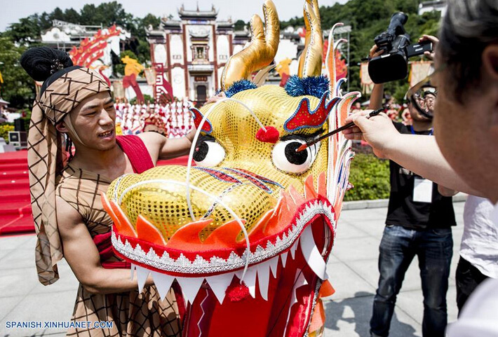 Un hombre dibuja el ojo de una marioneta de dragón durante una feria cultural para marcar el próximo Festival del Bote del Dragón, en el condado Zigui, capital de la provincia central de Hubei, China, el 8 de junio de 2016. El Festival del Bote de Dragón o "Duanwu" en chino, se celebra el quinto día del quinto mes del calendario lunar, celebrándose este año el 9 de junio. (Xinhua/Xiao Yijiu)