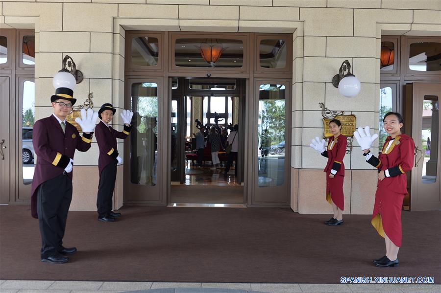 Empleados de recepción saludan a los visitantes en la entrada del Shanghai Disneyland Hotel en Shanghai, en el este de China, el 14 de junio de 2016. El Shanghai Disney Resort, el sexto en el mundo, abrirá oficialmente el 16 de junio. (Xinhua/Liu Xiaojing)