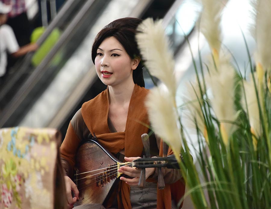 Una artista toca un instrumento musical antiguo durante el espectáculo de arte digital Night Revels of Han Xizai en el Aeropuerto Internacional de Beijing, el 21 de junio de 2016. 
