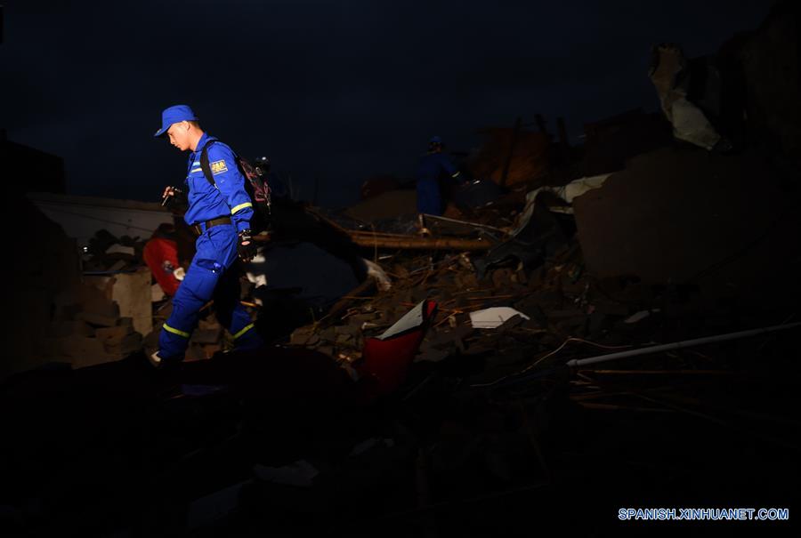 Un rescatista busca sobrevivientes en la aldea Beichen del condado de Funing, ciudad de Yancheng, en la provincia de Jiangsu, en el este de China, el 24 de junio de 2016. Al menos 78 personas murieron, mientras que cerca de 500 personas resultaron heridas, en uno de los desastres naturales más letales registrados en décadas en la provincia oriental china de Jiangsu. Aguaceros, granizadas y el peor tornado desde 1966 azotaron parte de la ciudad de Yancheng a las 14:30 hora local del jueves, destruyeron viviendas y dejaron atrapados a cientos de residentes del lugar bajo los escombros. (Xinhua/Han Yuqing)