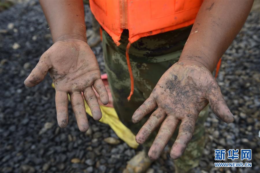 Un soldado que participó en el rescate de un dique en la provincia china de Jiangxi mostró las manos manchadas con lodos el 5 de julio. Tormentas azotaron varias provincias chinas ocasionando inundaciones. (Xinhua/Zhou Mi)