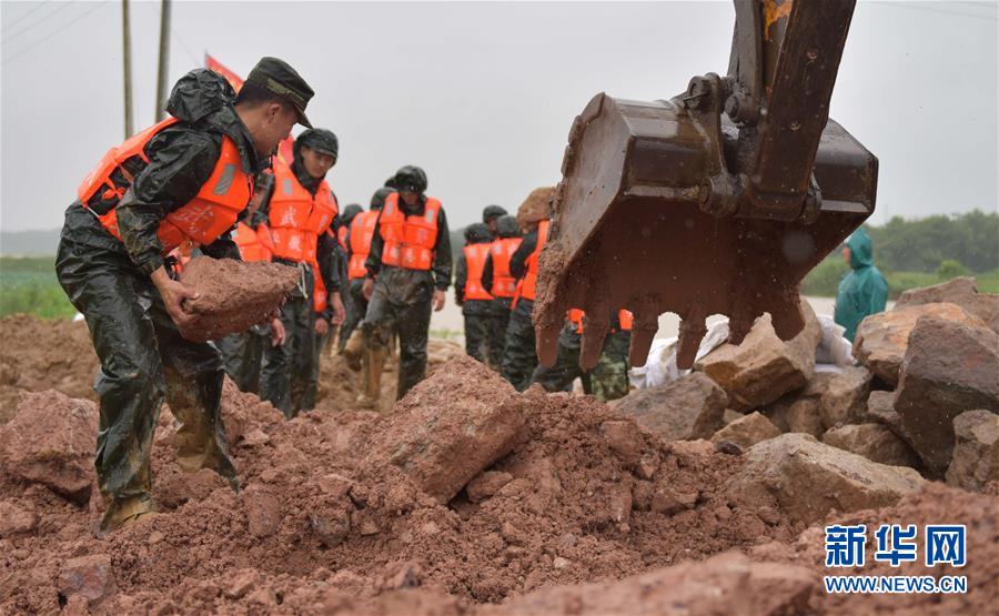 Policias armadas en la provincia china de Anhui cargaron piedras para reforzar un dique el 5 de julio. (Xinhu/Xu Wei)