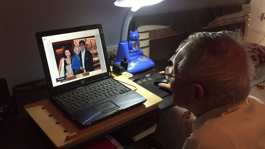 Wang mira la foto de un internado que él ayudó a liberar hace 71 años. [Fotografía de Jun/chinadaily.com.cn Yang]