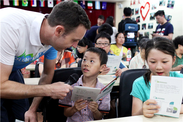 Timothy Clancy, estudiante australiano en la Universidad de Zhejiang, enseña inglés a los niños como voluntario para la próxima Cumbre del G20 en Hangzhou. XINGXIN ZHU / CHINA DAILY
