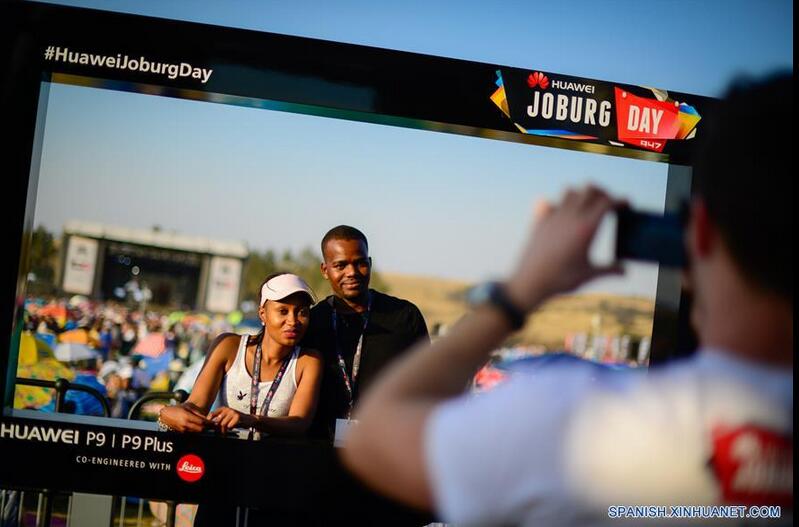 Un empleado toma una fotografía a una pareja durante el festival musical "Huawei Joburg Day", en Johannesburgo, Sudáfrica, el 3 de septiembre de 2016. El festival musical anual "Joburg Day", patrocinado en 2016 por la empresa china Huawei, comenzó el sábado con la participación de 11 grupos artísticos locales y bandas al que acudieron aproximadamente 22,000 visitantes. (Xinhua/Zhai Jianlan)