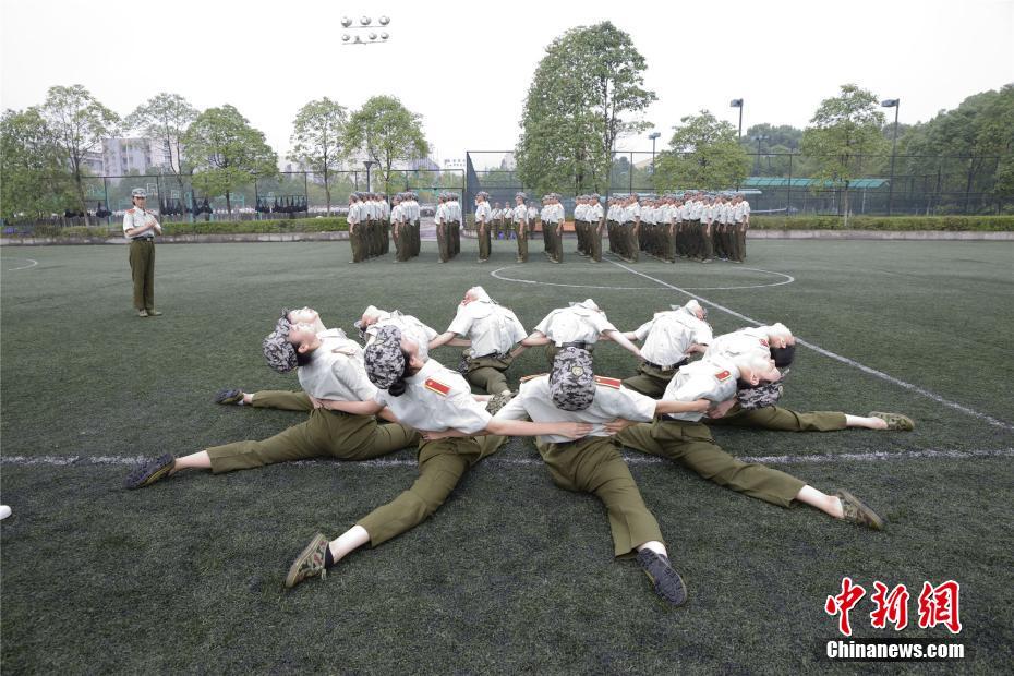 Las estudiantes de danzade la Universidad de Chongqing bailan en los descansos del entrenamiento militar