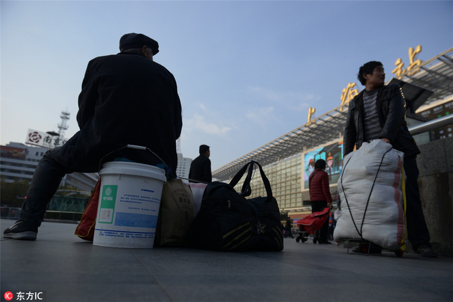 Dos trabajadores migrantes esperan en la estación de tren de Shanghai el 15 de diciembre de 2016. Muchos de los trabajadores migrantes han terminado sus trabajos antes de tiempo para evitar el éxodo masivo de viajeros. [Foto / IC]