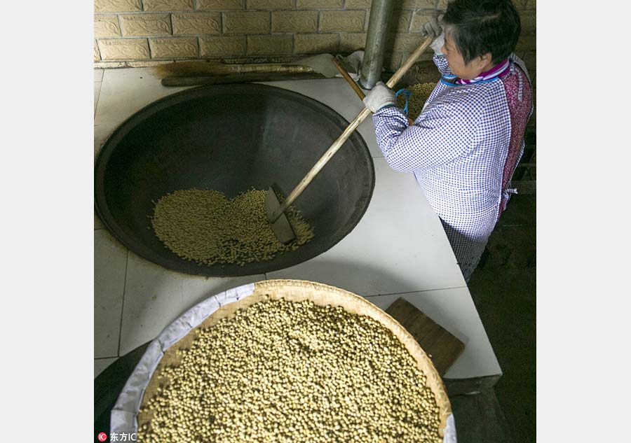 Un maestro de dulces tradicionales sofríe soja, uno de los tres ingredientes claves en el sabor del Zi Dou Tang. 