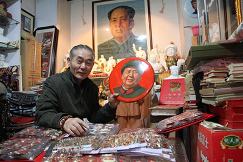 Wang Liansheng relata a los visitantes las diferentes historias que atesora su colección personal de insignias de Mao Zedong. Taiyuan, Shanxi. [Foto: IC]