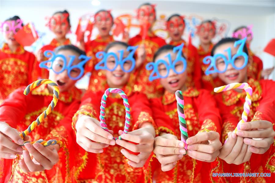 Estudiantes sostienen figuras de arcilla con la forma del "2017" para saludar el próximo Año Nuevo, en la ciudad de Qingdao, provincia de Shandong, en el este de China, el 31 de diciembre de 2016. (Xinhua/Liang Xiaopeng)
