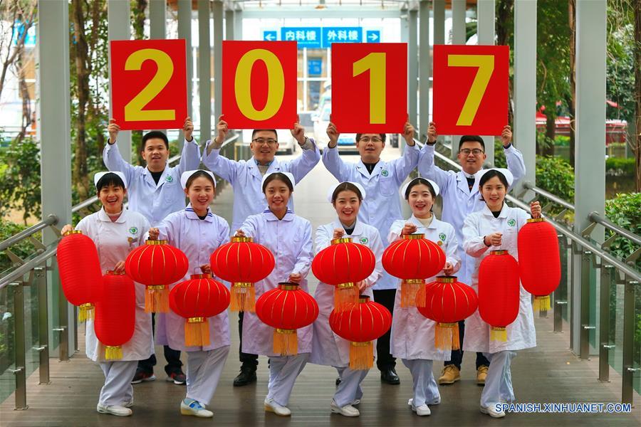 Trabajadores médicos sosteniendo linternas rojas y signos escritos con la leyenda del "2017" posan para saludar el próximo Año Nuevo, en la ciudad de Suining, provincia de Sichuan, en el suroeste de China, el 31 de diciembre de 2016. (Xinhua/Zhong Min)