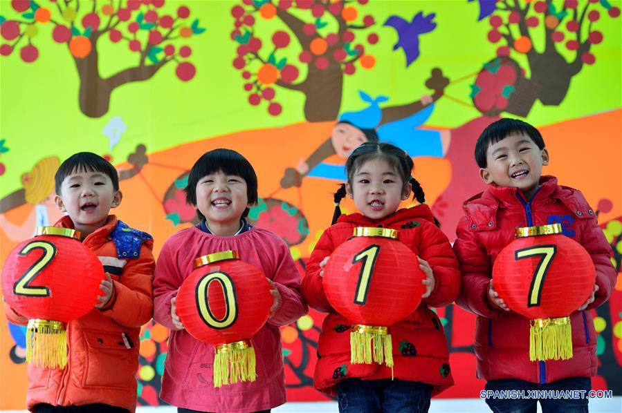 Imagen del 30 de diciembre de 2016 de niños sosteniendo linternas rojas con la leyenda "2017" para saludar el próximo Año Nuevo, en el condado de Baokang, provincia de Hubei, en el centro de China. (Xinhua/Yang Tao)