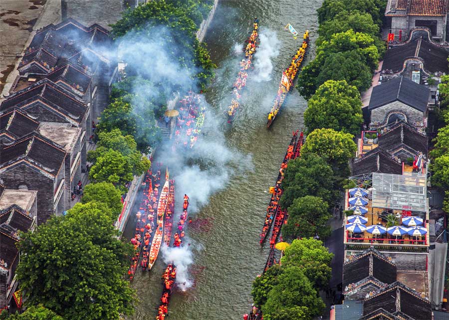 Carrera de botes de dragón en una ciudad con río. Foto de Zhang Yonglin. [Foto proporcionada por photoint.net]