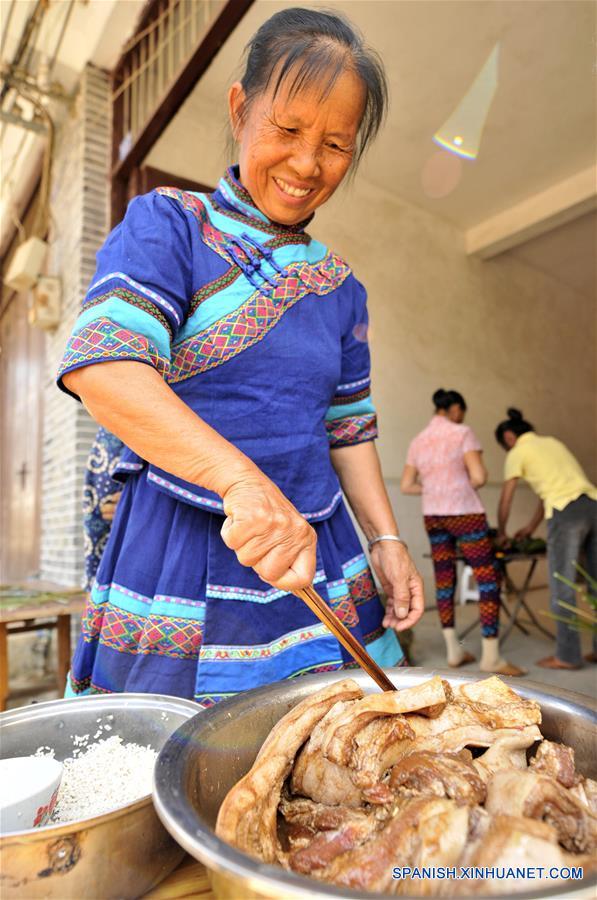 NANNING, mayo 29, 2017 (Xinhua) -- Imagen del 28 de mayo de 2017, de una mujer del grupo étnico Zhuang preparando los ingredientes para elaborar un "zhongzi" con forma de almohada en el municipio de Luobo en el distrito de Wuming de Nanning, en la Región Autónoma Zhuang de Guangxi, en el sur de China, el 29 de mayo de 2017. El "zongzhi"con forma de almohada en Luobo es elaborado con arroz glutinoso y carne. (Xinhua/Pan Huanqing)