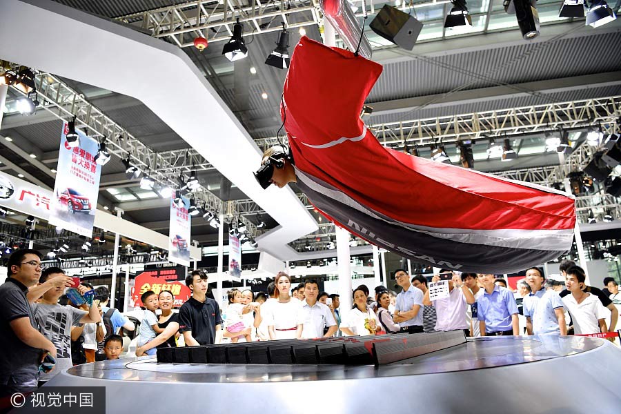 Una modelo muestra como experimentar un salto de altura gracias a la realidad virtual en el XXI Salón Internacional del Automóvil de Shenzhen-Hong Kong-Macao en Shenzhen, provincia de Guangdong, el 4 de junio de 2017. [Foto / VCG]