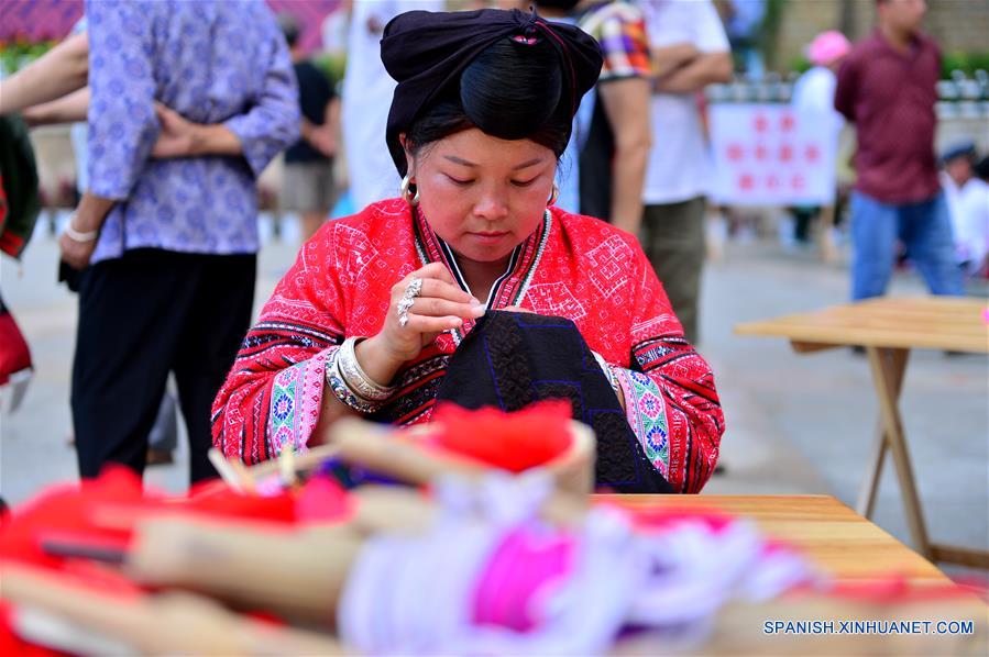  Una mujer del grupo étnico Yao muestra cómo elaborar prendas tradicionales de su etnia, durante una exhibición de patrimonio cultural en Longsheng, en la Región Autónoma Zhuang de Guangxi, en el sur de China, el 9 de junio de 2017. (Xinhua/Li Xuanli)  