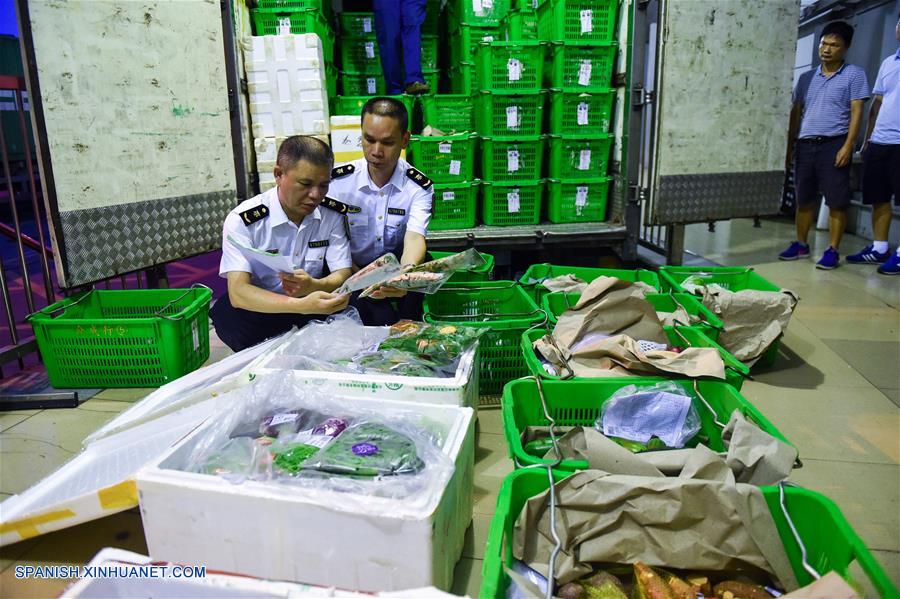 GUANGDONG, junio 18, 2017 (Xinhua) -- Imagen del 16 de junio de 2017, de empleados de inspección y cuarentena revisando la mercancía en el puerto de Wenjindu en Shenzhen, en la provincia de Guangdong, en el sur de China. Según las estadísticas de las autoridades locales, más del 85 por ciento de los vegetales, frutas y aves de corral vivas que llegaron desde la parte continental de China a los mercados de Hong Kong, fueron transportados a través del puerto Wenjindu de Shenzhen. (Xinhua/Mao Siqian)
