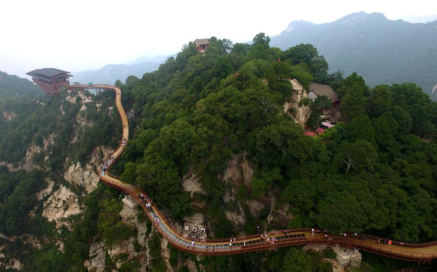 Turistas contemplan la majestuosidad de la montaña Shaohua desde su osado mirador