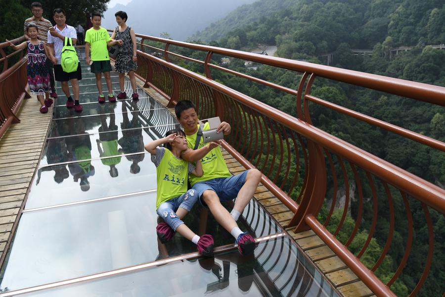 Turistas contemplan la majestuosidad de la montaña Shaohua desde su osado mirador