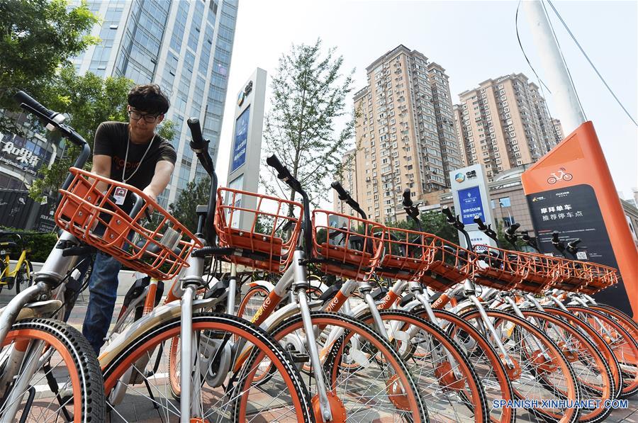  TIANJIN, agosto 21, 2017 (Xinhua) -- Un despachador de bicicletas compartidas acomoda bicicletas frente a un centro comercial en Tianjin, en el norte de China, el 21 de agosto de 2017. A pesar del clima sofocante en Tianjin, los despachadores, que también son trabajadores de mantenimiento, viajan por la ciudad para asegurar que las biciclets estén en orden y funcionen bien. (Xinhua/Shi Songyu) 