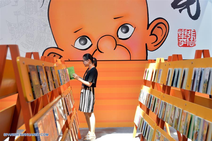 Una visitante lee un libro en la 24 Feria Internacional del Libro de Beijing llevada a cabo en la Nueva Sede del Centro Internacional de Exposiciones de China, en Beijing, capital de China, el 23 de agosto de 2017. (Xinhua/Wang Huajuan)