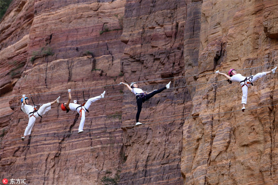 Entusiastas del Yoga practican en el acantilado de una gran montaña