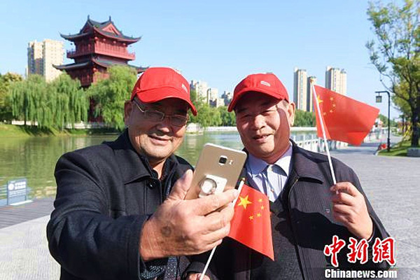 Dos ciudadanos de la tercera edad se toman una foto durante su viaje a Huai'an, provincia de Jiangsu, 24 de octubre del 2017. [Foto: chinnews.com]