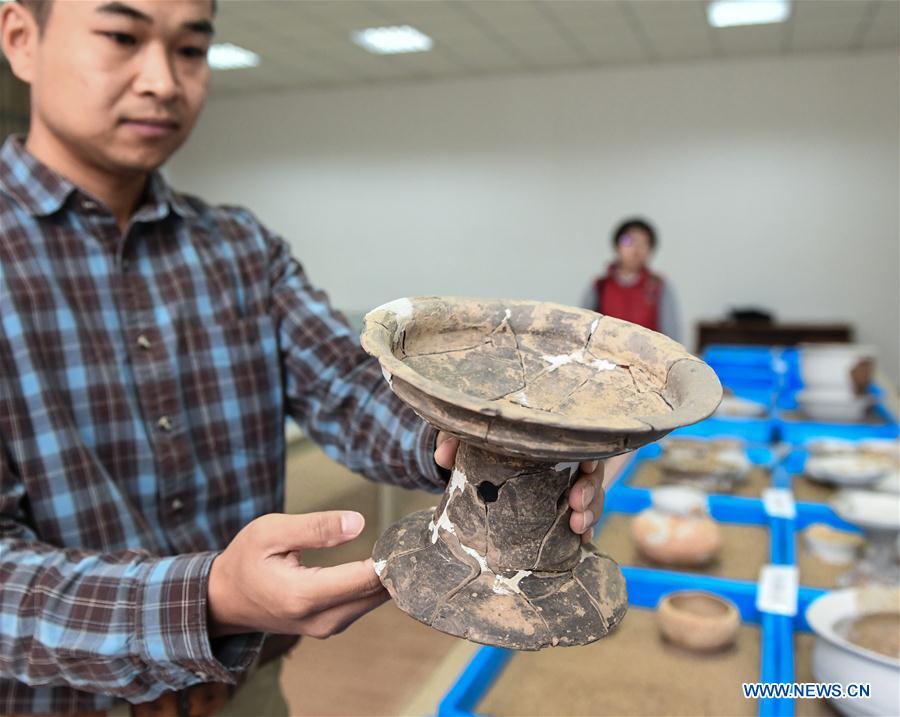 Un arqueólogo muestra cerámica en las ruinas de Nanshan, provincia de Fujian, sureste de China, el 5 de noviembre de 2017. Los arqueólogos chinos han encontrado una gran cantidad de granos de arroz carbonizados en cuevas que datan de la Nueva Edad de Piedra, desafiando la visión convencional de que los habitantes de las cavernas eran únicamente cazadores y que no cultivaban tierra para alimentarse. (Xinhua / Li He)
