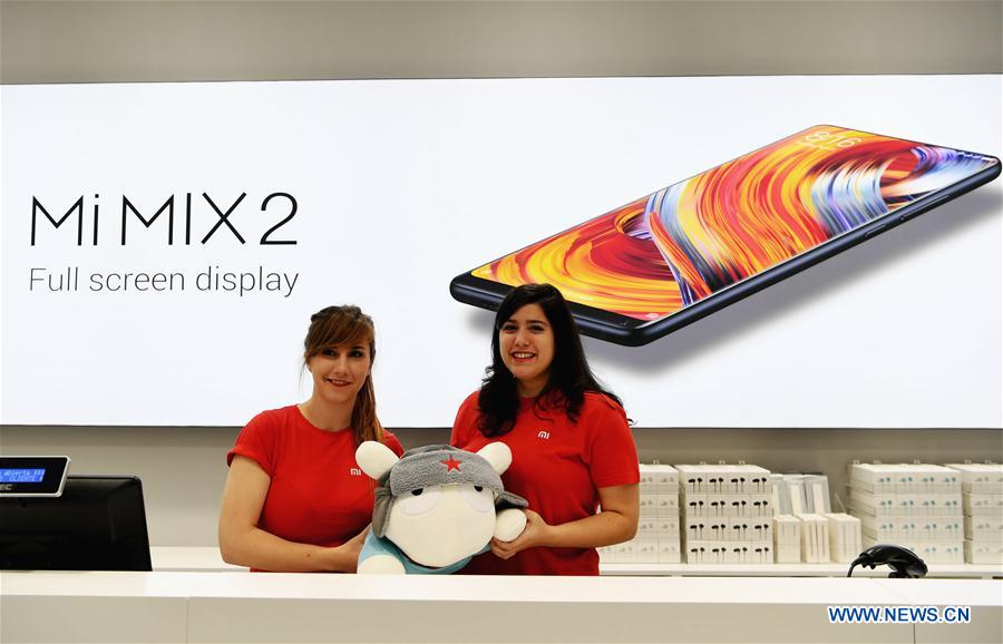 Dos trabajadorasmuestran el muñecoXiaomi en una tienda en Madrid, capital de España, el 11 de noviembre de 2017. Xiaomi, una de las principales empresas de alta tecnología de China, abrió el sábado por la mañana sus dos tiendas a través de vendedores autorizados en Madrid. [Foto / Xinhua]