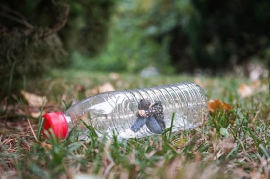 Una foto con el tema "Nunca tires al suelo las botellas de plástico" muestra a una mujer atrapada en la botella de plástico. (Foto provista a chinadaily.com.cn)