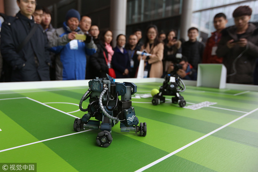 Dos robots juegan al fútbol ante la mirada de los visitantes en la Cumbre Mundial de Fabricación Inteligente en Nanjing, provincia de Jiangsu, el 6 de diciembre de 2017. [Foto / IC]