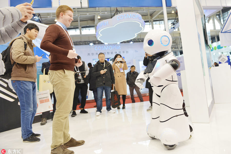 Un participante extranjero aprende a bailar con un robot en la Cumbre Mundial de Fabricación Inteligente en Nanjing, provincia de Jiangsu, el 6 de diciembre de 2017. [Foto / IC]