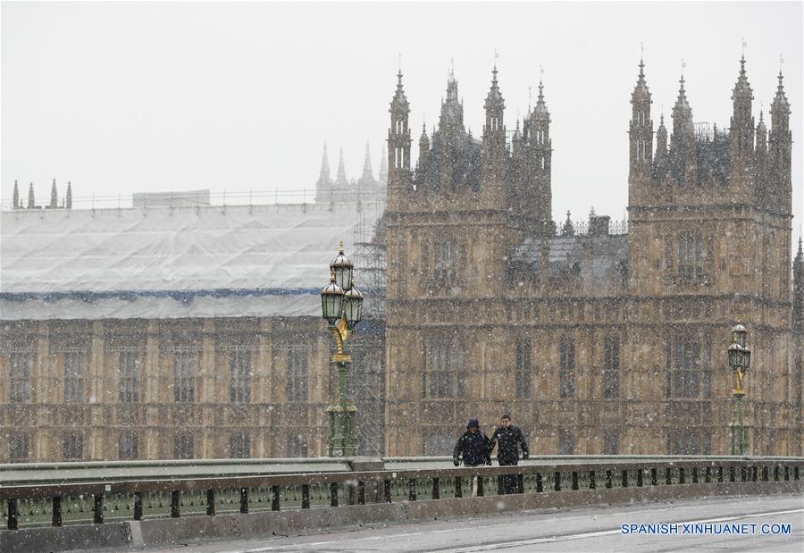 Personas caminan por el Puente de Westminster durante una nevada, en el centro de Londres, Reino Unido, el 10 de diciembre de 2017. (Xinhua/Han Yan)