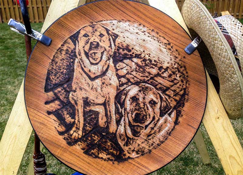 La artista estadounidense Michael Papadakis utiliza, a través de una lupa, la luz solar refractada y reflejada para pirograbar la madera. En esta obra retrata la alegría de los perros. [Foto: IC]