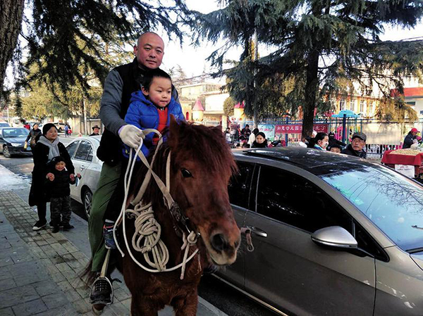 Un padre recoge a su hijo a caballo en una guardería de Xianyang