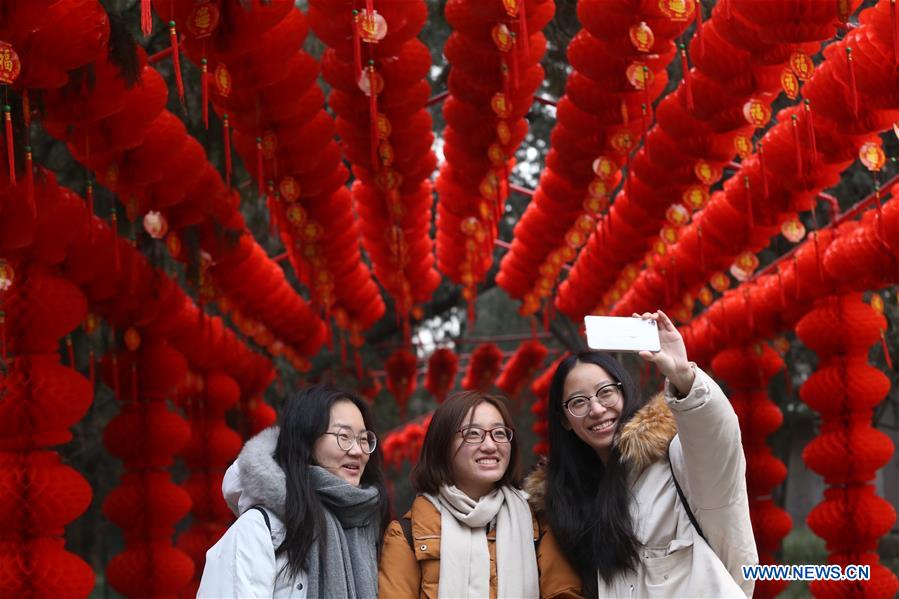 Visitantes disfrutan de la belleza festiva del parque Ditan, conocido también como el parque del Templo de la Tierra. Este lugar ha sido decorado con farolillos rojos para celebrar el próximo Festival de la Primaverao Año Nuevo Lunar Chino, Beijing, 27 de enero del 2018. [Foto: Xinhua]