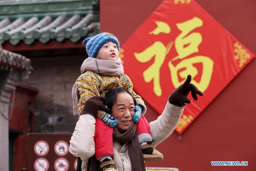 Visitantes disfrutan de la belleza festiva del parque Ditan, conocido también como el parque del Templo de la Tierra.Este lugar ha sido decorado con farolillos rojos para celebrar el próximo Festival de la Primaverao Año Nuevo Lunar Chino, Beijing, 27 de enero del 2018. [Foto: Xinhua]