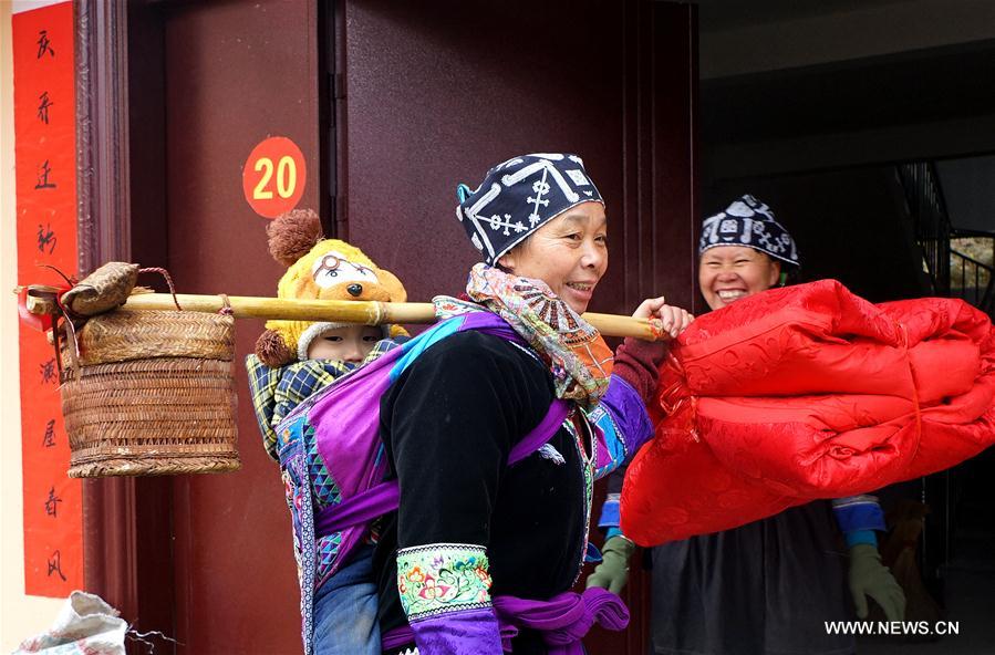 Miembros de bajos recursos del grupo étnico Dong se mudan a nuevas casas en la aldea Rongdi en Sirong, municipio autónomo Rongshui Miao, Región Autónoma de Guangxi Zhuang. Gracias a la política de mitigación de la pobreza, 2.093 familias disfrutan de nuevas viviendas proporcionadas por el gobierno de Rongshui. 26 de enero del 2018. [Foto: Xinhua]
