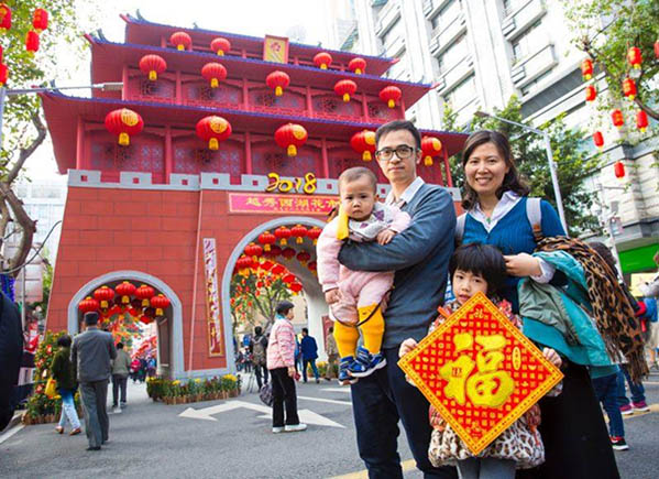 Una familia desea "feliz año nuevo" para todo el mundo mientras disfruta del mercado de las flores de Guangzhou. [Foto: proporcionada]