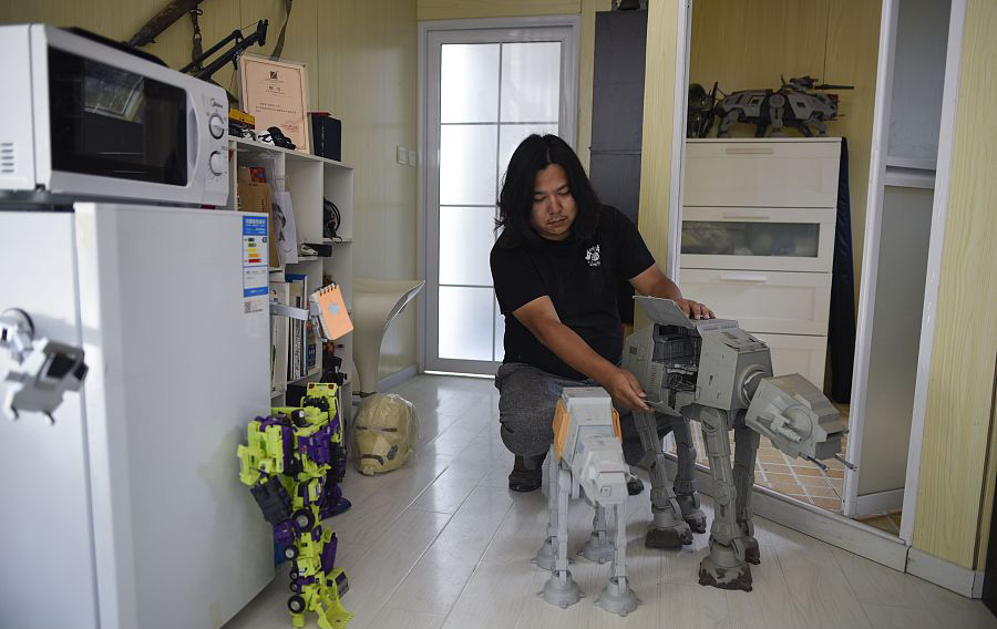 El escultor chino Sun Shiqian arma un perro robot en su estudio de Beijing. [Foto: VCG]