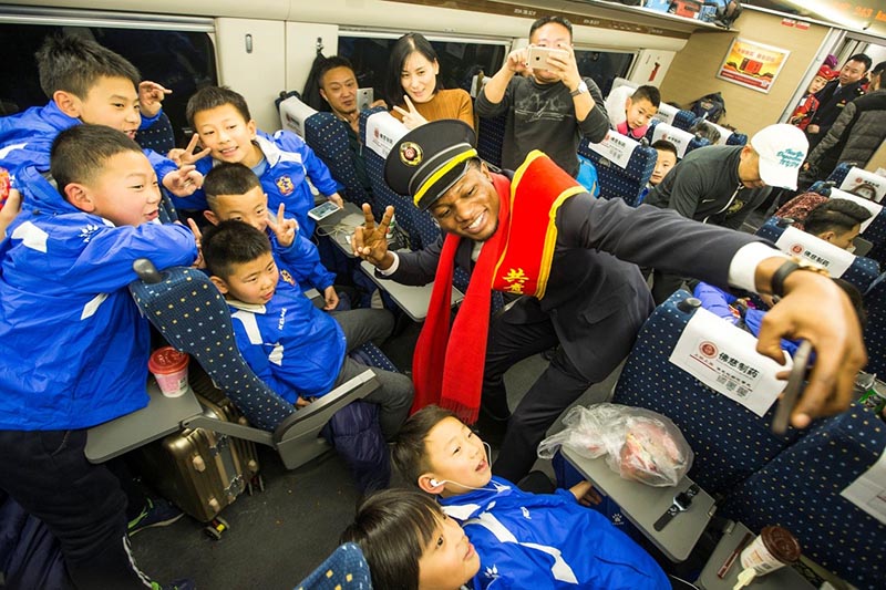 El primer día del Festival de la Primavera del año 2018, en el tren Xicheng de alta velocidad D1925, los estudiantes extranjeros voluntarios se hicieron fotos con los pasajeros chinos más jóvenes. Fuente de la imagen: Pueblo en Línea