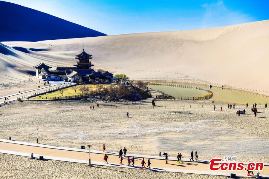 Los turistas visitan las montañas arenosas cantantes de Dunhuang 