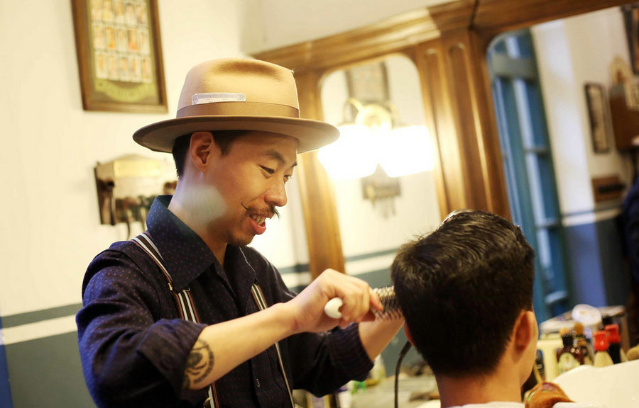 En “La barbería”, Henry realiza un peinado de antaño. Shanghai, 5 de abril del 2018. (Foto: IC)
