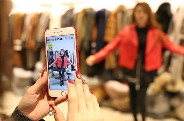 Vivi, una dependienta de 28 años, transmite en vivo durante más de dos horas al día, mostrando la ropa que se vende en su tienda. [Foto de Zou Hong / China Daily]