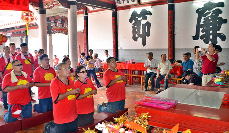 Huang Chi-Tsung (al frente y a la izquierda) y los miembros de su familia oran en el templo ancestral dedicado a los Huang en Pujin, provincia de Fujian.
