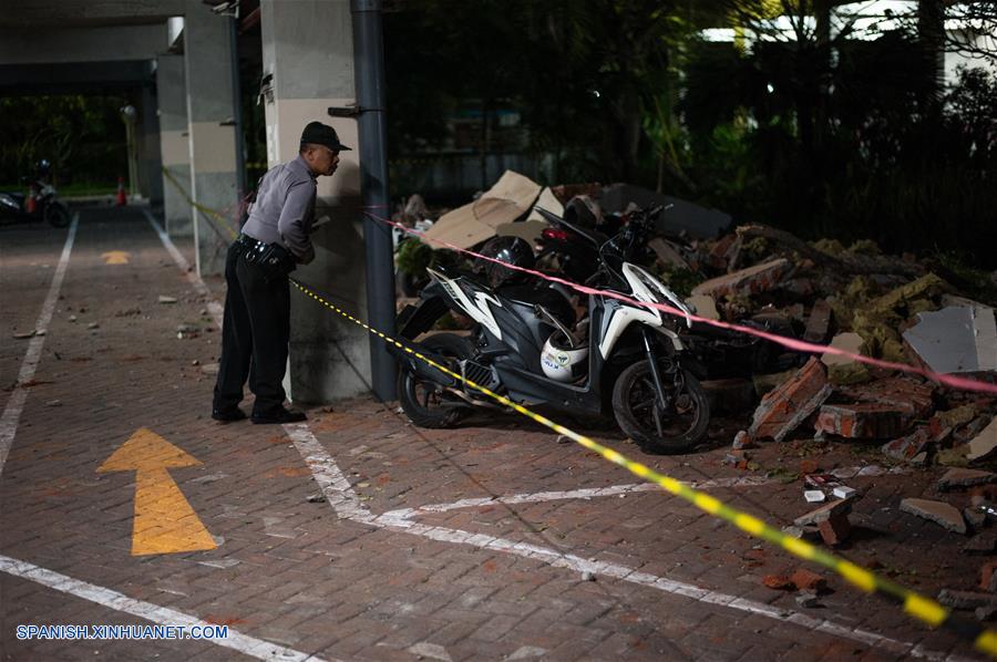 Un oficial de seguridad revisa los escombros esparcidos por un estacionamiento después de que ocurriera un terremoto, en la Regencia Badung, Bali, Indonesia, el 5 de agosto de 2018. (Xinhua/Muhammad Fauzi Chaniago)
