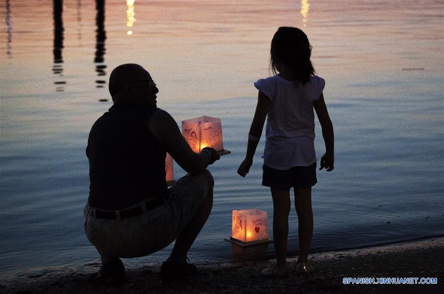 MARYLAND, agosto 5, 2018 (Xinhua) -- Imagen del 4 de agosto de 2018 de un hombre preparándose para soltar linternas de agua durante un festival de linternas de agua, en el Puerto Nacional, en Maryland, Estados Unidos. Las linternas fueron puestas a flote el sábado para iluminar el Río Potomac con motivo del Festival de Linternas de Agua, creando una muestra espectacular de luces. (Xinhua/Liu Jie)