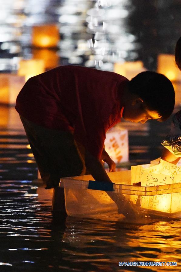MARYLAND, agosto 5, 2018 (Xinhua) -- Imagen del 4 de agosto de 2018 de un niño colocando una linterna de agua durante un festival de linternas de agua, en el Puerto Nacional, en Maryland, Estados Unidos. Las linternas fueron puestas a flote el sábado para iluminar el Río Potomac con motivo del Festival de Linternas de Agua, creando una muestra espectacular de luces. (Xinhua/Liu Jie)